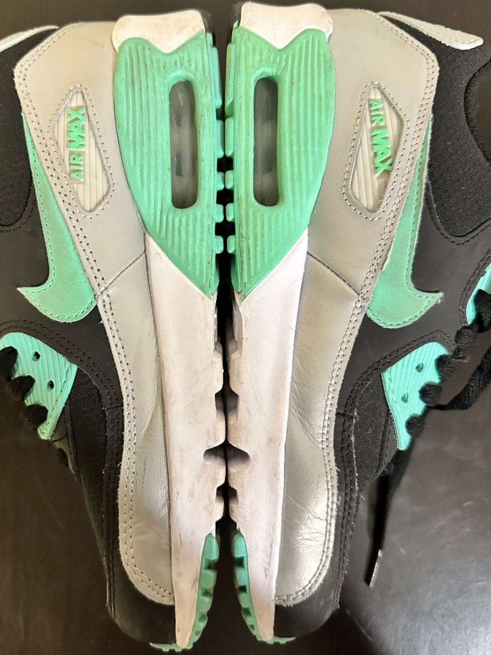 The Nike Air Max 90 in the Black/Green Glow/Metallic Platinum colorway